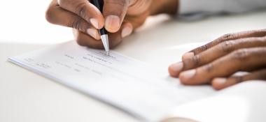 Closeup of someone signing a check